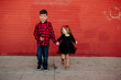 © Erin Brant/Stocksy - Portrait of brother and sister in front of red wall