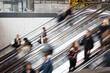 © Alejandro Moreno de Carlos/Stocksy - Unrecognizable blurred people on escalator in shopping center