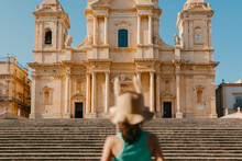 Tourist With Hat In Front Of Palazo Nicolaci In Noto, Sicily.