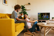 © BONNINSTUDIO/Stocksy - Merry couple relaxing near TV in weekend
