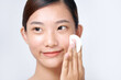 © Marc Tran/Stocksy - Woman using cotton pad. Happy smiling beautiful young woman