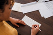 © Milles Studio/Stocksy - Crop female freelancer signing letter
