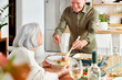© ALTO IMAGES/Stocksy - Senior man serving food for woman