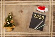 New year concept, on a wooden background, 2022 number on a black notebook.