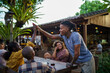 © Jovo Jovanovic/Stocksy - Young Black man giving high five to friend at outdoor restaurant