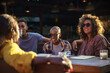 © Jovo Jovanovic/Stocksy - Friends sitting together at sunny table outside