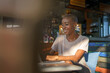 © Jovo Jovanovic/Stocksy - Smiling professional using laptop at cafe