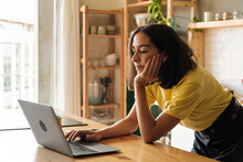 Young Woman Browsing Laptop At Home