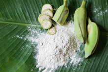 Banana Powder On Wooden Bowl And Raw Banana - Banana Fruit On Leaf Background, Alternative Flour, Homemade Green Banana Flour For Herbal Medicine Nature Herb