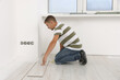 © New Africa - Professional worker installing new laminate flooring indoors