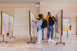 © VICTOR TORRES/Stocksy - Diverse friends looking at university posters on a bulletin board