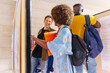 © VICTOR TORRES/Stocksy - Diverse friends looking at university posters on a bulletin board