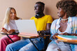 © VICTOR TORRES/Stocksy - Group of diverse classmates sitting on chairs at university