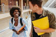 © VICTOR TORRES/Stocksy - Cheerful multiethnic students with textbooks in university