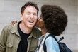 © VICTOR TORRES/Stocksy - Cheerful multiethnic couple kissing at university