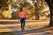 © Drazen - Happy athletic woman taking a walk through autumn park.