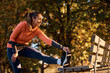 © Drazen - Happy athletic woman stretching her leg on bench in park.