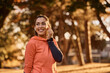 © Drazen - Happy athletic woman using earbuds while exercising in nature.