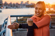 © Drazen - Happy athletic woman stretching her arms while exercising outdoors at sunset.