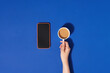 © Marc Tran/Stocksy - Top view blank notebook and coffee with smartphone on blue background.