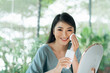 © Marc Tran/Stocksy - Cheerful asian girl cleaning her face, using cotton pad
