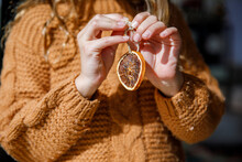 Girl Preparing Ornament With Dried Orange Slice During Christmas