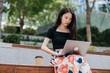 © Heng Yu/Stocksy - Businesswoman  working on a laptop outdoor