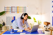 © ByLorena/Stocksy - Latin woman with headset working in cool office