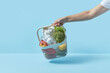 © Yaroslav Danylchenko/Stocksy - Organic food in plastic basket held by woman.
