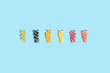 © Jelena Sijak/Stocksy - Spiral pasta pattern in different colors on a blue background.