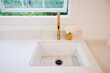 © Trinette Reed/Stocksy - Kitchen sink with white matte countertop