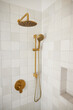 © Trinette Reed/Stocksy - Gold shower fixture in bathroom
