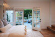 © Trinette Reed/Stocksy - Bedroom in cottage home with outdoor patio