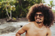 © Leonardo Borges/Stocksy - Man with afro hair on the beach.