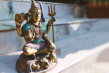 Wall Mural - Bronze figurine of Lord Shiva with a trident decorated with stones.