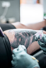 Tattooist Spraying Rose Water On The Tattoo
