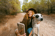 Girl With Hat Taking A Funny Selfie With Her Dog Outdoor In Sunlight