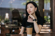 © Heng Yu/Stocksy - Portrait of woman in a cafe