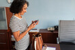 © Lightsy/Stocksy - A woman using a cell phone in the office