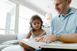 © Tanya Yatsenko/Stocksy - Father reads a book to his daughter