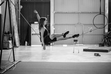 Flexible Sportswoman Sitting On Tightrope