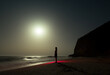 © Ibai Acevedo/Stocksy - Standing woman looking at the moon at dreamlike night beach
