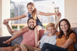 © Alexis S/peopleimages.com - Family, love and relax on a sofa by children with parents in living room, happy and smile while bonding in their home. Portrait, happy family and kids with mom and dad in lounge, cheerful and playful