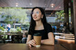 © Heng Yu/Stocksy - Portrait of woman in a cafe