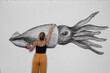 © Yakov Knyazev/Stocksy - collage of a woman drawing large squid on the paper