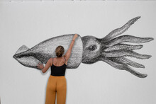 Collage Of A Woman Drawing Large Squid On The Paper