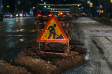 Road Works Ahead Sign At Winter Night Street Near Pit