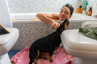© Luis Velasco/Stocksy - Woman Taking A Bath Next To Her Dog.