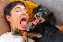 Funny Girl And Cute Dog Yawning On The Couch.