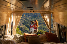 Happy Couple With Camper Van In Nature